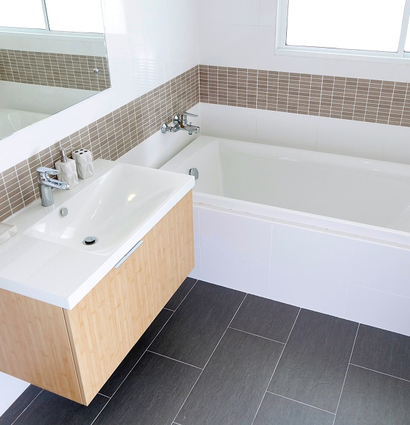 Salle Bain Moderne : Vasque, Baignoire et Carrelage Chic Salle de bain moderne avec vanité flottante en bois clair, lavabo blanc, baignoire encastrée et carrelage mural blanc et taupe.